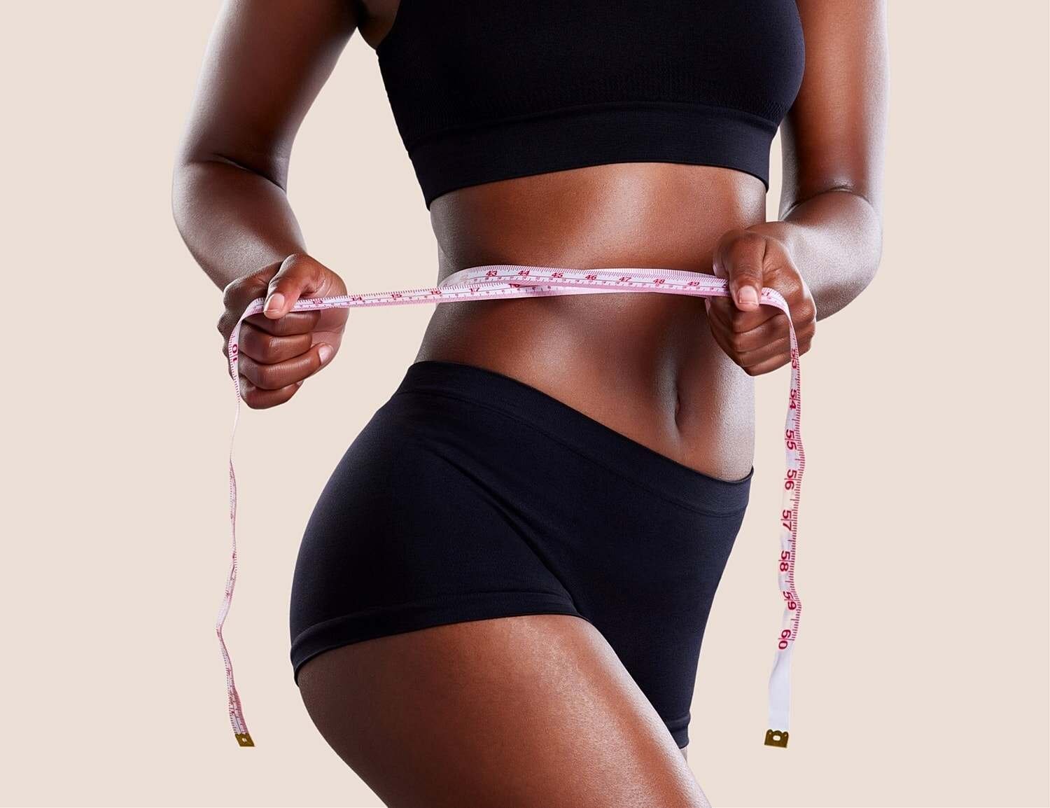 Model in stylish white swimsuit against greenery.