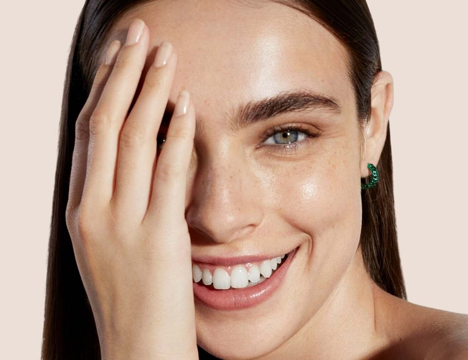 Woman with voluminous curly hair against white background.